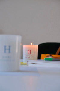 A softly glowing Huskke & Co candle on a desk, capturing the quiet atmosphere where candle scents transform a simple space into something serene and intentional.