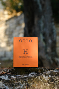 Huskke & Co Otto candle box on a mossy stone, capturing the essence of burning candles for relaxation and natural ambiance.